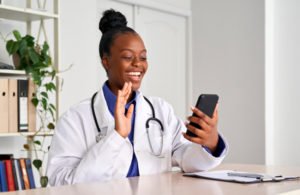Female doctor waving at patient on video call