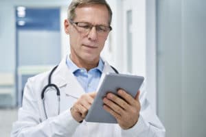 Male doctor looking at tablet/smart device