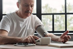 older man taking blood pressure at home