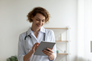 Female doctor smiling looking at iPad