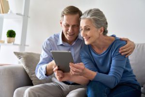 elderly couple looking at ipad