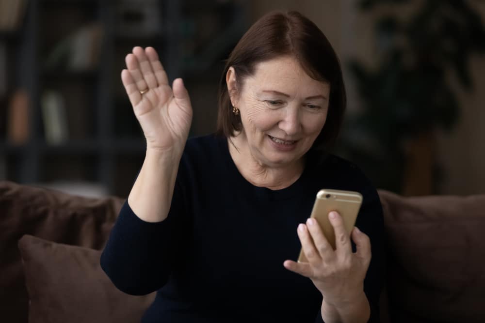woman waving wild holding iphone