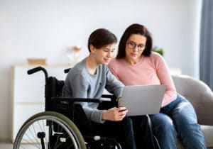 Mom and son in wheelchair on laptop