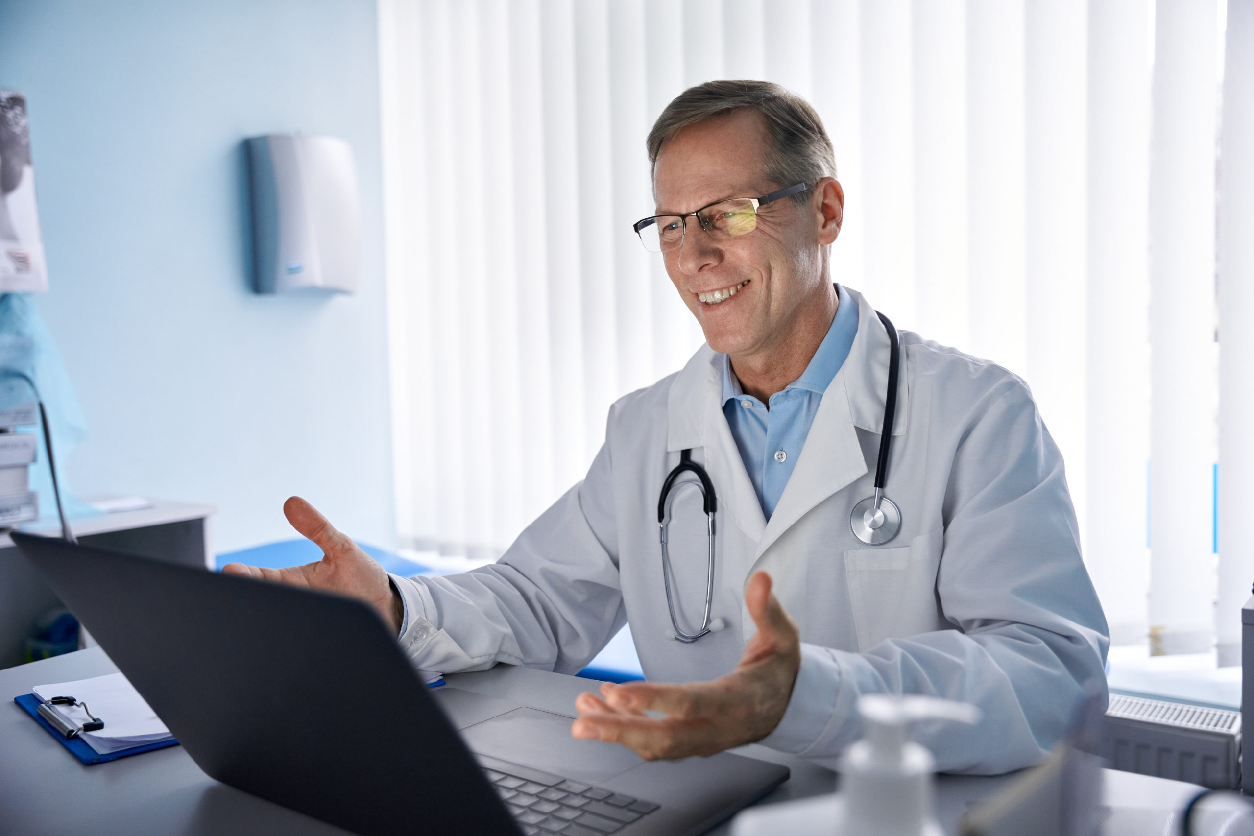 Male doctor smiling at computer