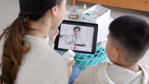 parent and child on virtual call with doctor